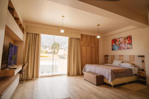 卡哈马卡Suite Spa Puñuykuna的一间卧室设有一张床和一个大窗户