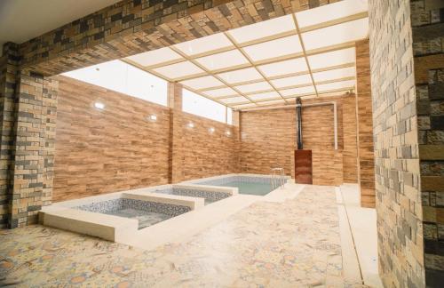 卡哈马卡Suite Spa Puñuykuna的大型客房设有游泳池和砖墙