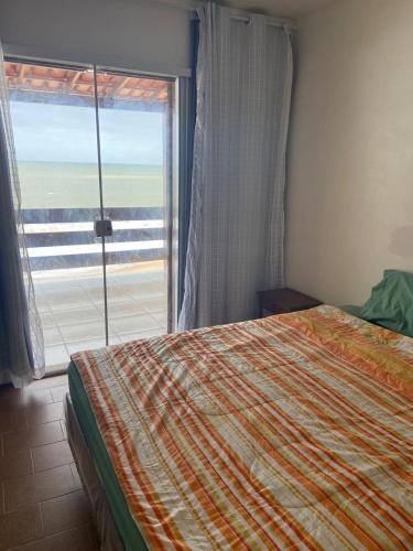 里约达欧特拉斯Casa de Praia PÉ NA AREIA em Rio das Ostras RJ的一间卧室设有一张床和一个大窗户