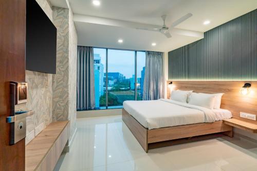海得拉巴Harvey's Hotels (Gachibowli)的一间卧室设有一张床和一个大窗户