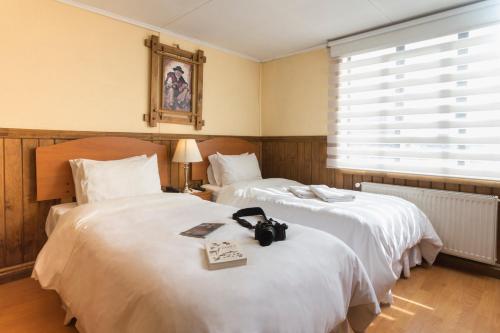 蓬塔阿雷纳斯西罗苏尔旅馆的一张床铺,位于酒店客房内,床上有一本书