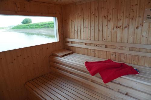 勒沃库森Hafen Perle - Übernachtungen auf dem Wasser- Romantik & Wellness auf dem Rhein -的木制桑拿房,设有窗户和红色毛巾