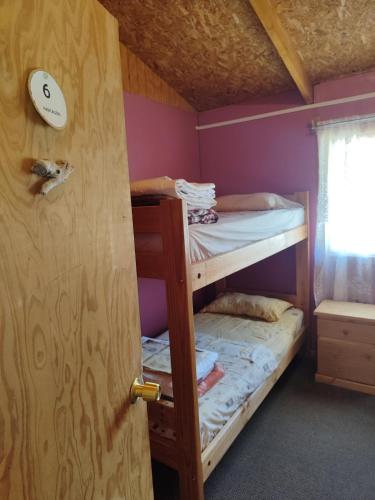 安东尼奥港Alma Patagona Hostel的双层床间 - 带两张双层床和一扇门