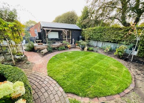法纳姆High spec studio cabin-Farnham centre的房屋前带圆形草坪的花园
