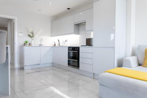 卡迪夫Luxury Cardiff City Centre Apartments的白色的厨房配有白色的橱柜和沙发