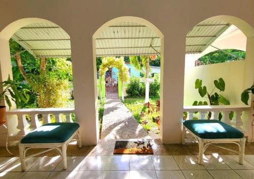 Oracabessa绿宫牙买加酒店的一个带两把椅子的门廊,享有庭院的景色