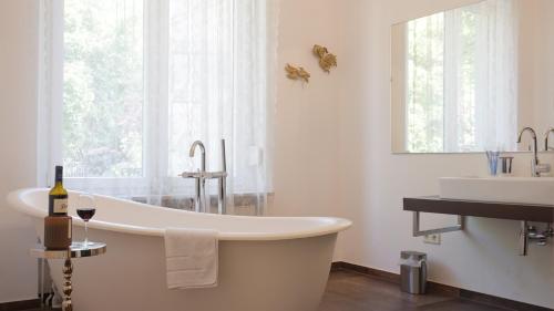 奥斯纳布吕克Heger Tor Apartments的白色的浴室设有浴缸和水槽。