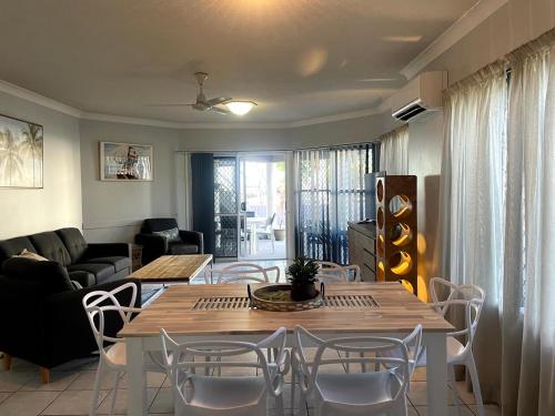 赫维湾Villa Venezia Apt 3 - Spacious Hervey Bay beachfront apartment的客厅配有桌椅和沙发