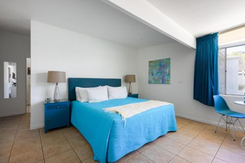 棕榈泉Monkey Tree Hotel by AvantStay Stylish Hotel in Palm Springs w Pool的一间卧室配有蓝色的床和蓝色椅子