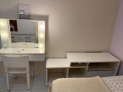 里约热内卢Casa Zona Sul的卧室配有白色的办公桌和镜子