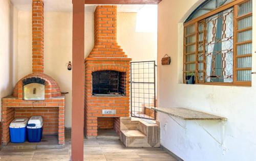 索罗卡巴Otima casa de campo com churrasq em Sorocaba SP的砖炉,坐在建筑物内
