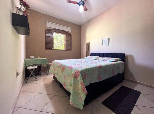 索罗卡巴Otima casa de campo com churrasq em Sorocaba SP的一间卧室配有一张床、一张桌子和一个窗户。