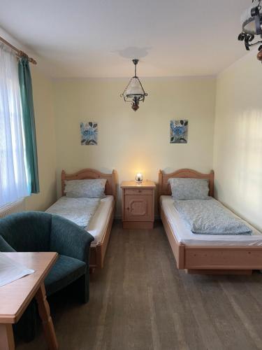 OberkotzauLandgasthof - Braukeller - Fattigau的客房设有两张床、一张沙发和一张桌子。