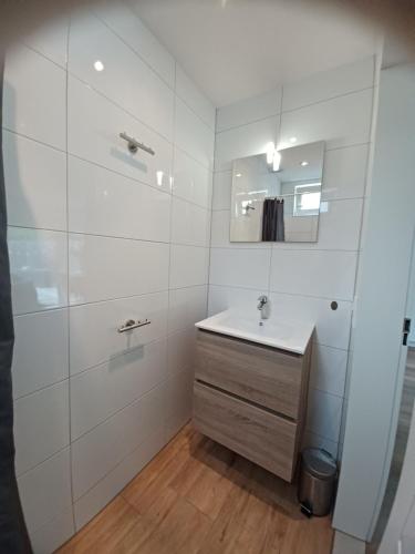 佐特兰德Bosweg 9a, Comfortabele vakantiewoning, Centrum Zoutelande的白色的浴室设有水槽和镜子
