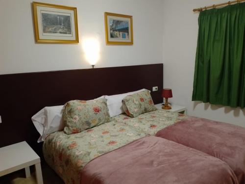 洛思坎加约斯Casa Lago Azul 49的一间卧室配有床和绿帘