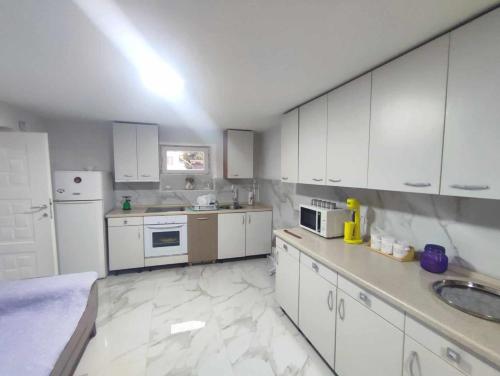 克鲁舍沃Apartments Janiki的厨房配有白色橱柜和白色家电