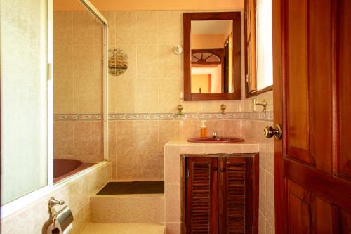 埃斯孔迪多港Casona H的一间带水槽、浴缸和镜子的浴室