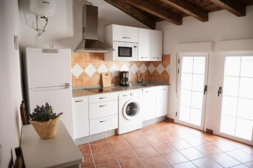 特鲁希略VIVE Trujillo的厨房配有白色橱柜、洗衣机和烘干机