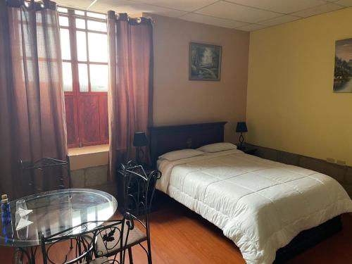 里奥班巴METROPOLITANO HOTEL的一间卧室配有一张床和一张玻璃桌