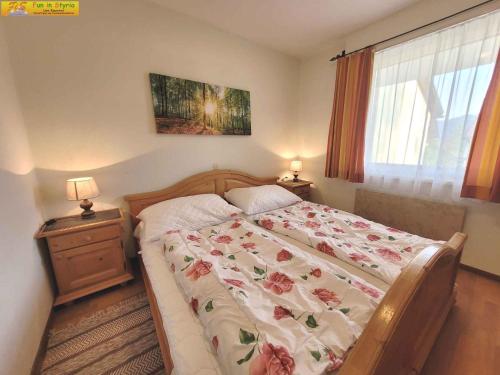 巴德米滕多夫Holiday home in Bad Mitterndorf - Steiermark 41124的一间卧室配有一张带花卉床罩的床和窗户。