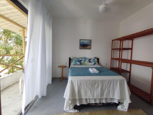 伊列乌斯Casa Aroeira Pousada的一间带床的卧室,位于带窗户的房间内