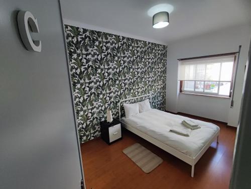克卢什Sintra, T3 with terrace in Massama, Queluz, Sintra的一间小卧室,配有一张床和一面墙
