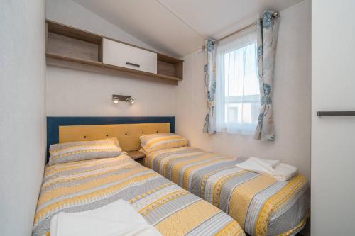 塞顿港Lisa Marie-Luxury Caravan-Seton Sands-8 Berth的一间小房间设有三张床,设有窗户