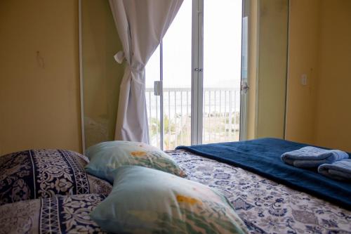 伊塔波阿Casa do Farol的卧室配有带枕头的床铺和窗户。