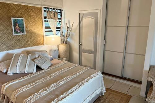 帕皮提BUNGALOW F2 Atypical local style的一间卧室配有一张大床和镜子