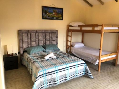 瓜塔佩Cabañas Campestres Bosque Encantado的一间卧室配有两张双层床和一张床