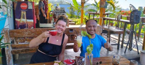 SapitBalelangga Bed & Breakfast的男人和女人在桌子上喝饮料