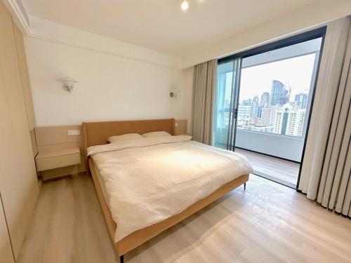 上海ZHome-Modern 3 bedrooms apartment - near NanJing Road的一间卧室设有一张大床和一个大窗户