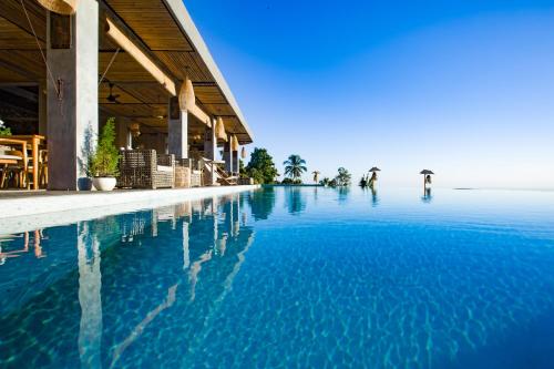 罗威那Maha Hills Resort Lovina的蓝色的建筑旁边的游泳池