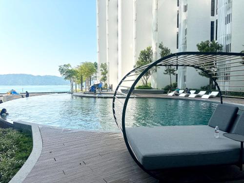 哥打京那巴鲁The Shore Kota Kinabalu City Centre by LW Suites的坐在大楼游泳池旁的长凳