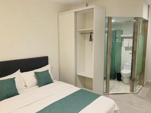 上海自在居酒店式公寓（虹桥龙柏新村店）的一间卧室配有一张床,浴室设有卫生间