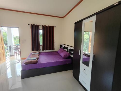 Ban PhayunDowslom Place的一间卧室,在房间内配有一张紫色的床