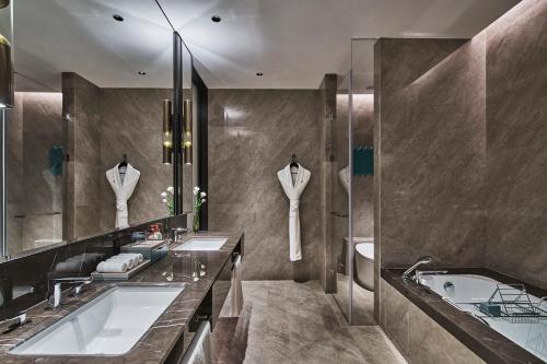 赣州赣州皇冠假日酒店的浴室配有两个盥洗盆和浴缸。