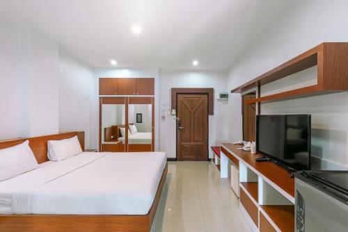 PattaniRiver Hotel Pattani的一间卧室配有一张床和一台平面电视
