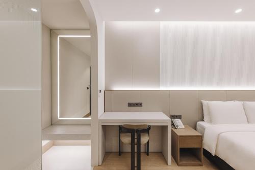 釜山阿班酒店的一间卧室配有一张床,一张桌子位于床边
