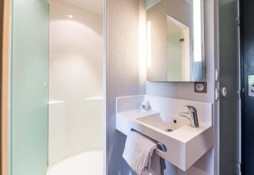 Sainte-Marie-de-CuinesB&B HOTEL Saint Jean De Maurienne的白色的浴室设有水槽和淋浴。