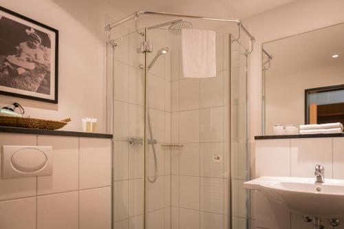 Niederzier伯格奥本多尔夫酒店的带淋浴和盥洗盆的浴室
