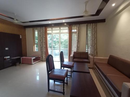 马哈巴莱斯赫瓦尔oakwood mahabaleshwar的客厅配有沙发和桌椅