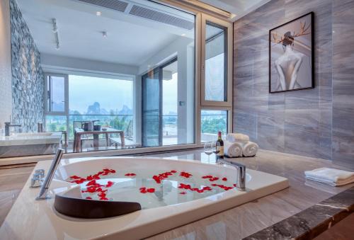 阳朔桂林阳朔水舍一线江景别墅的浴室设有装有红色鲜花的浴缸。