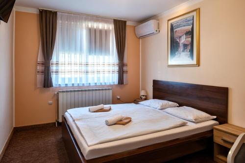 BosiljevoB&B Restoran Bosiljevo的一间卧室配有一张床,上面有两条毛巾