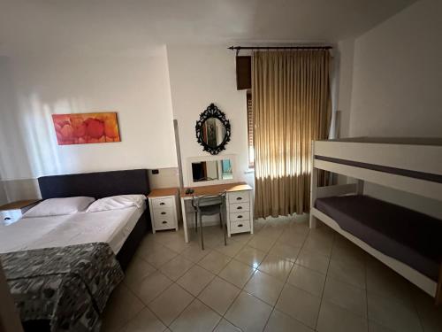 波佐利Hotel Le Pinede Vistamare的配有一张床和一张书桌的酒店客房