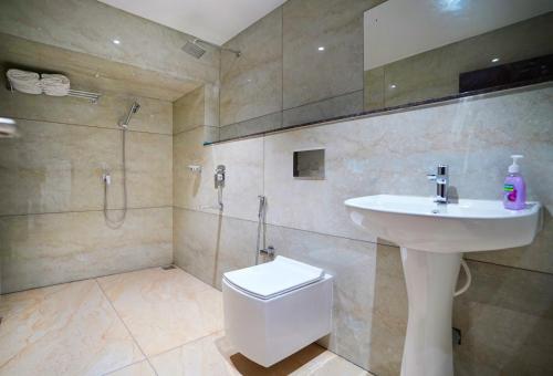 阿鲁法7 The Business Hotel的一间带水槽、卫生间和淋浴的浴室
