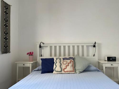托雷拉皮罗Holiday Home Eurovillage的一间卧室配有一张带两张白色桌子的床