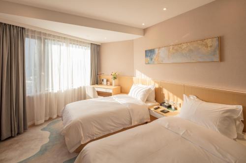 上海上海城市酒店的酒店客房设有两张床和窗户。