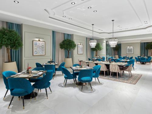 麦加麦加贾巴尔奥马尔地标酒店的一间配备有蓝色椅子和桌子的用餐室
