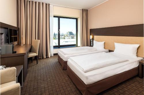 汉堡汉堡戴姆多梅塞会展中心城际酒店的酒店客房配有两张床和一张书桌